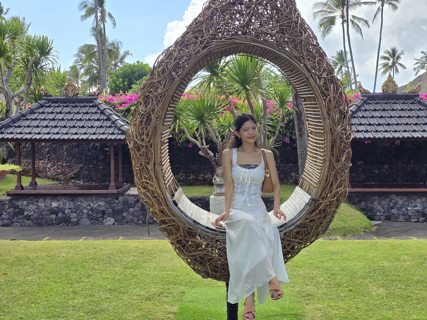 Jemi in a woven nest chair, white outfit